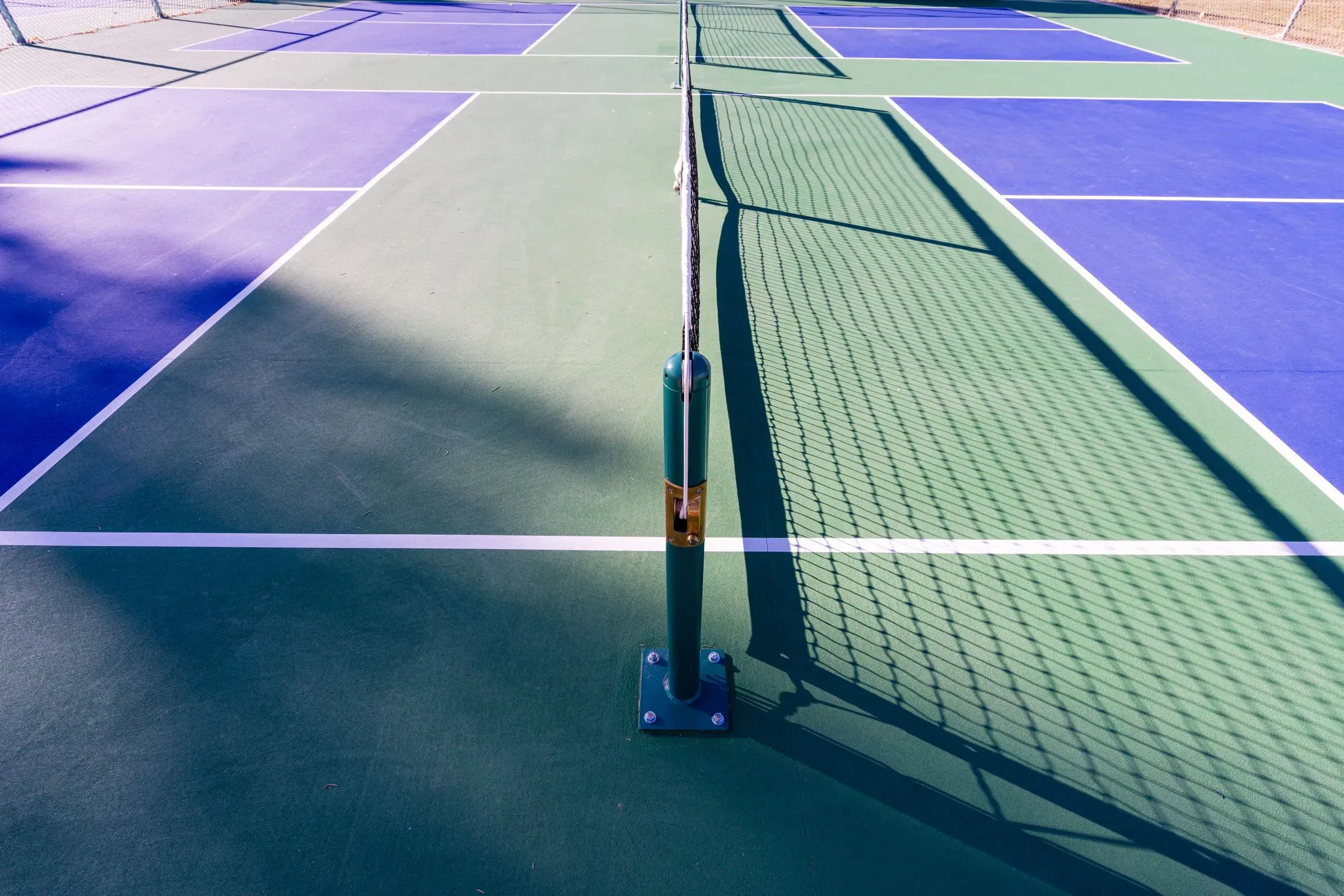 Síť a čáry na kurtu pro pickleball, u sítě je kuchyně (non-volley zone).